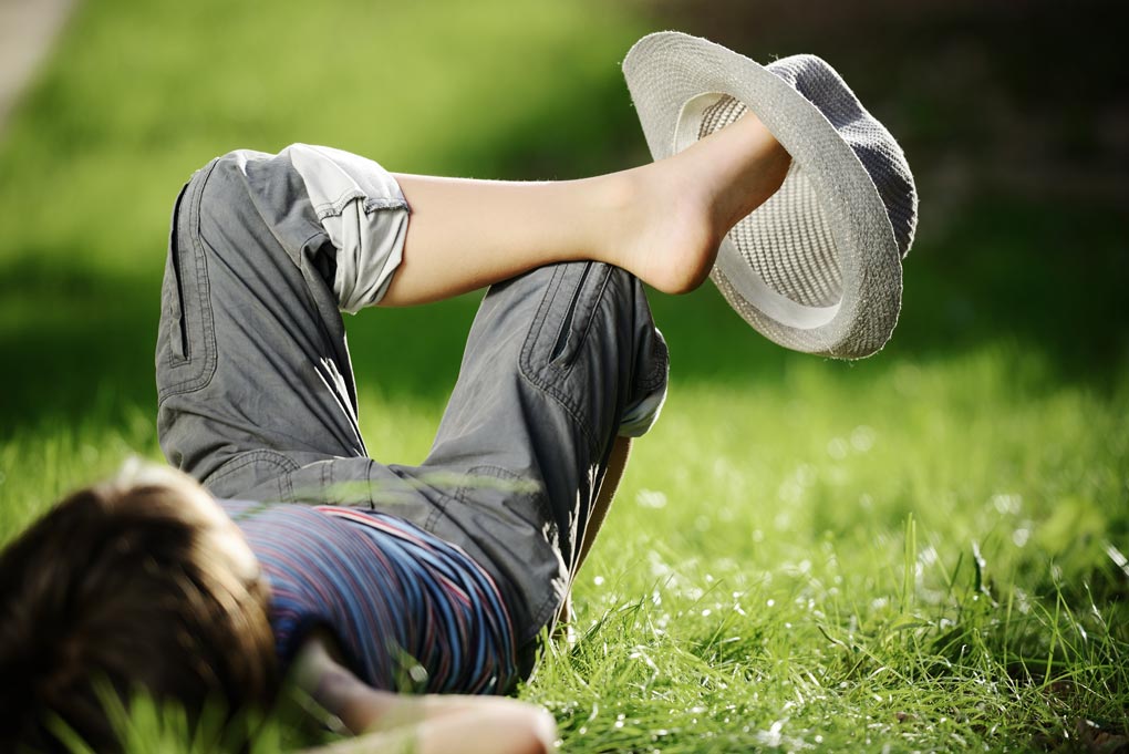 Relaxed Kid Resting On Summer Park Grass Meadow