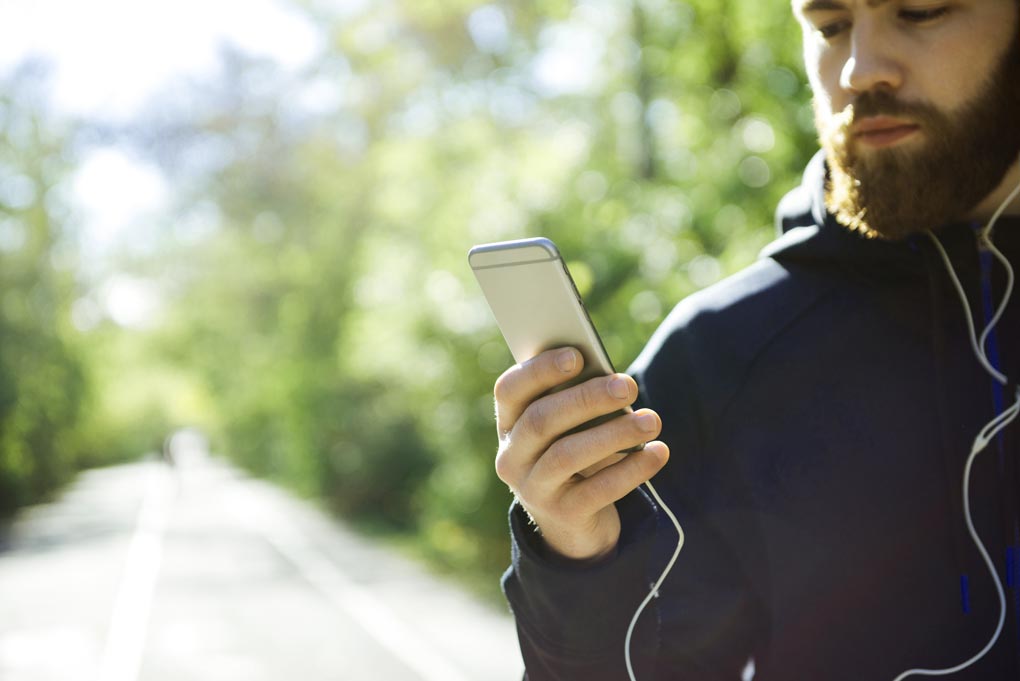 athletic runner with phone in park